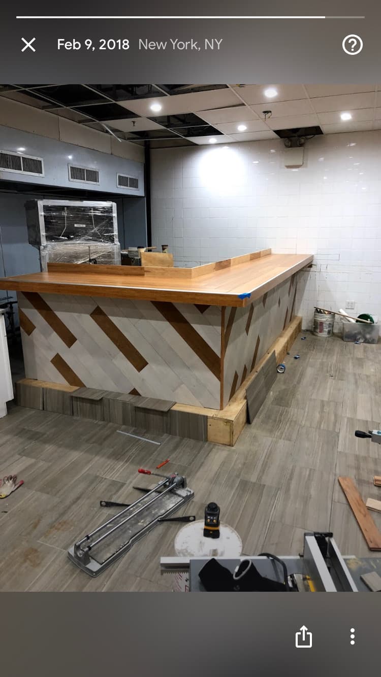 Custom bar with geometric tile pattern and wood countertop