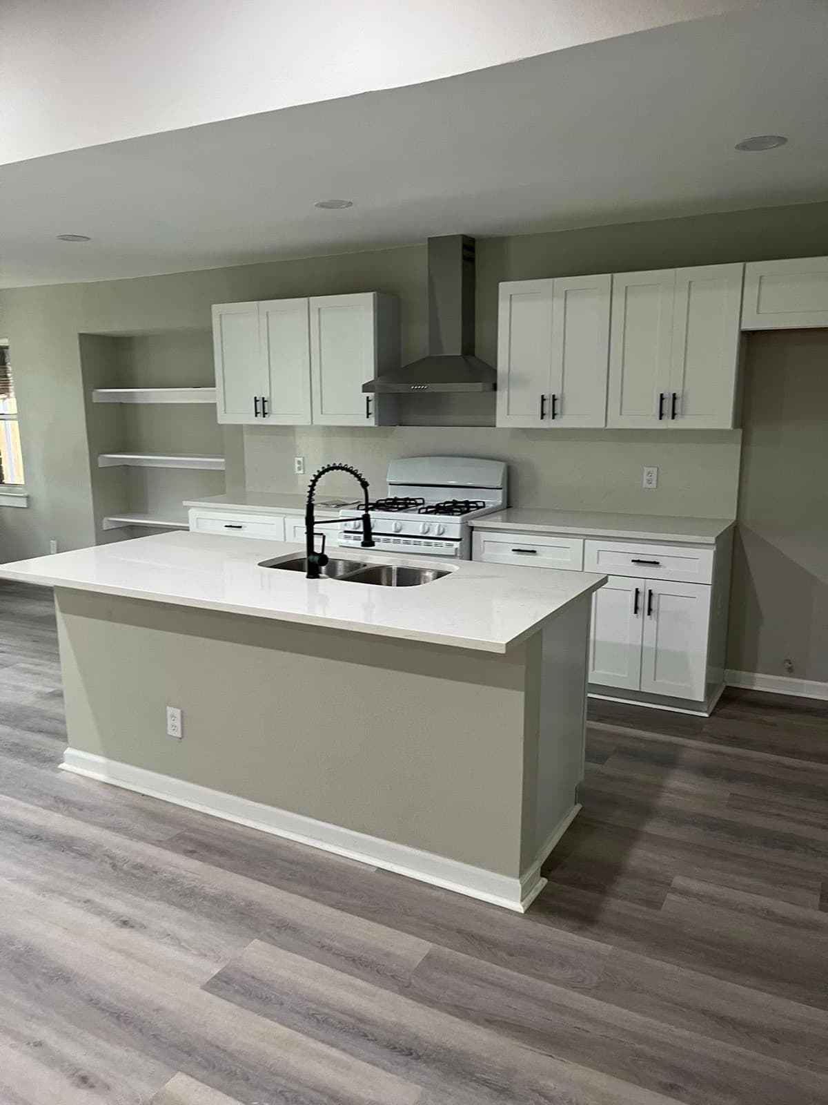 Kitchen with white shaker cabinets and quartz island