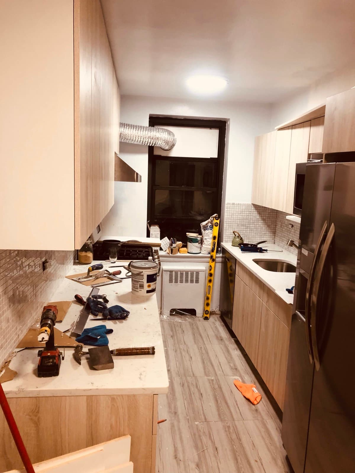 Kitchen renovation in progress with cabinetry and backsplash